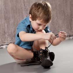 Motorische Störungen bei Kindern äußern sich im Alltag, etwa beim Anziehen oder beim Binden der Schnürsenkel