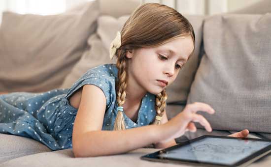 Medienkompetenz Sicherheit im Internet: Mädchen auf Sofa vor Laptop